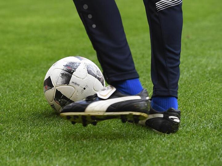 Ein Mann mit Fußballschuhen spielt einen Fußball. Foto: picture alliance / Tobias Hase/dpa/Symbolbild