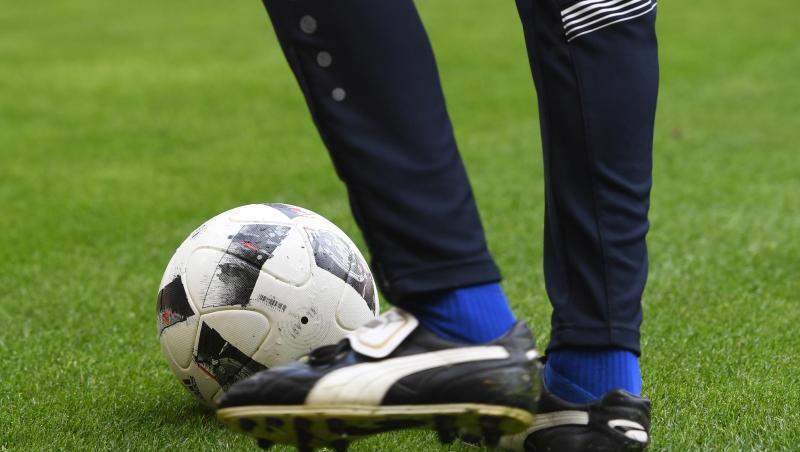 Ein Mann mit Fußballschuhen spielt einen Fußball. Foto: picture alliance / Tobias Hase/dpa/Symbolbild