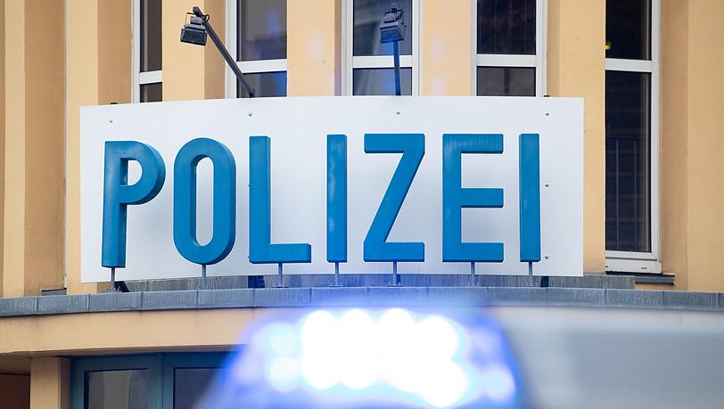 Ein Einsatzwagen der Polizei steht vor einer Dienststelle.