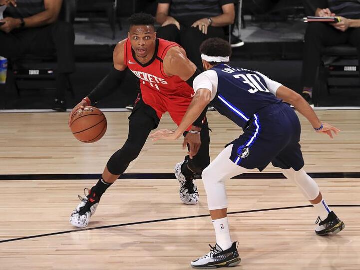 Russell Westbrook (l) von den Houston Rockets dribbelt gegen Seth Curry (r) von den Dallas Mavericks.
