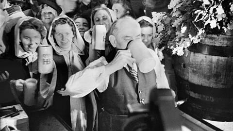 16. September 1950: Der damalige Oberbürgermeister Thomas Wimmer genießt den ersten Schluck seiner Maß nach dem Anzapfen. Zuvor hatte er 19 Schläge gebraucht.