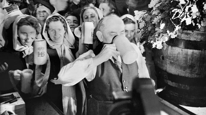 16. September 1950: Der damalige Oberbürgermeister Thomas Wimmer genießt den ersten Schluck seiner Maß nach dem Anzapfen. Zuvor hatte er 19 Schläge gebraucht.