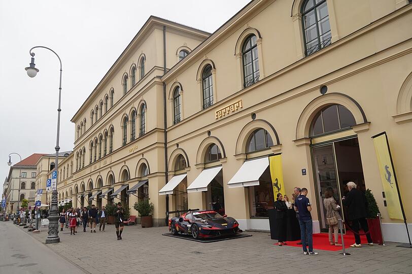 Zwischen Tambosi und Schumann's ist Ferrari eingezogen.  Draußen parkt am Eröffnungstag ein Rennwagen auf dem Gehsteig.