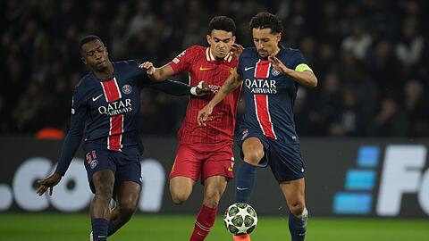 Nicht nur Liverpools Luis Diaz (M) hatte gegen die Pariser Willian Pacho (l) und Marquinhos mächtig Probleme.
