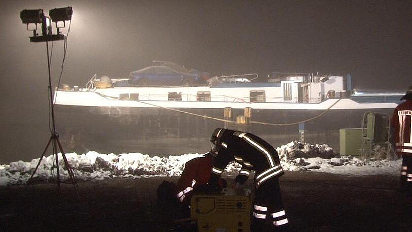 Feuerwehrleute sind am Hafen von Surwold nahe des Container-Schiffes im Einsatz, das bei dem Zusammenstoß mit einer Brücke beschädigt wurde. Feuerwehrleute sind am Hafen von Surwold nahe des Container-Schiffes im Einsatz, das bei dem Zusammenstoß mit einer Brücke beschädigt wurde.