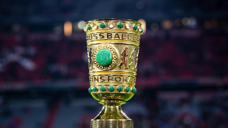 Der DFB-Pokal steht am Spielfeldrand.