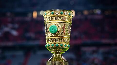 Der DFB-Pokal steht am Spielfeldrand.