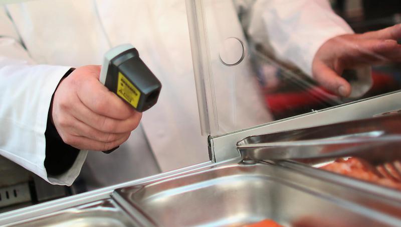 Ein Kontrolleur misst die Temperatur von Lachsfilets. Ein Kontrolleur misst die Temperatur von Lachsfilets.