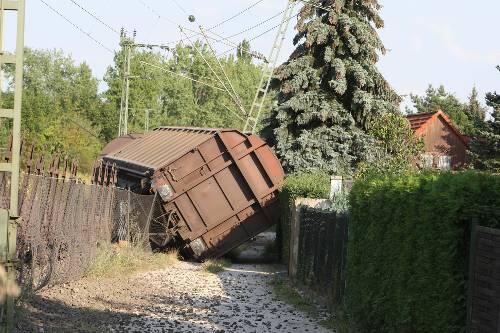 Der entgleiste Waggon knickte den Mast der Oberleitung um. E kam erst kurz vor der Hecke eines Privatgartens zum Stehen.
