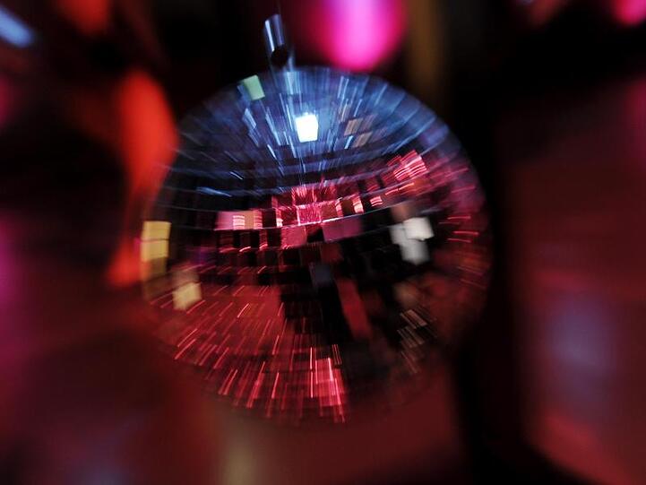 Eine Discokugel dreht sich im Licht. Foto: picture alliance / dpa/Symbolbild