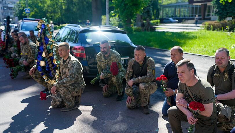 Ukrainische Soldaten knien während der Trauerfeier für einen Offizier in Schytomyr nieder. Nach Angaben von Kampfgefährten wurde er im Kampf gegen russische Truppen von einer Granate getötet. Ukrainische Soldaten knien während der Trauerfeier für einen Offizier in Schytomyr nieder. Nach Angaben von Kampfgefährten wurde er im Kampf gegen russische Truppen von einer Granate getötet.