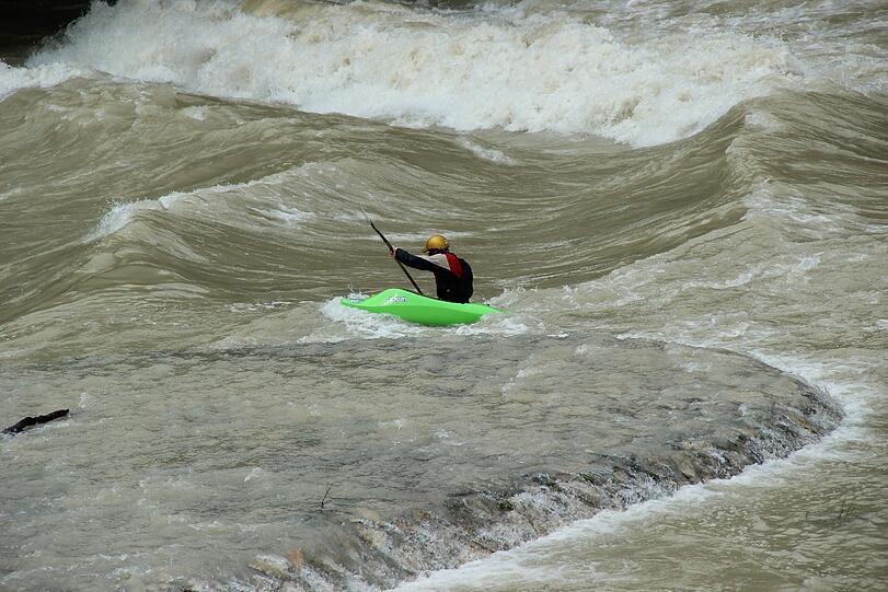 Hochwasser für die einen, perfekte Wellen für die anderen. Waghalsig tummeln sich Sportler in der Isar.