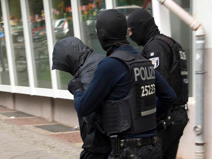 Polizeibeamte führen im Juli in Berlin einen Mann ab.