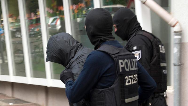 Polizeibeamte führen im Juli in Berlin einen Mann ab. Polizeibeamte führen im Juli in Berlin einen Mann ab.