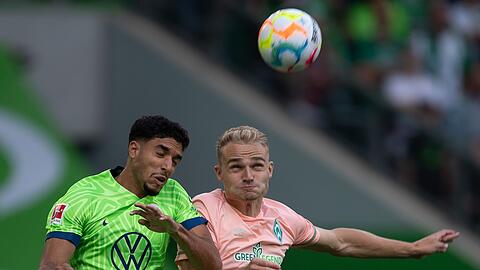 Wolfsburgs Omar Marmoush (l) liefert sich mit Bremens Amos Pieper ein Kopfballduell.