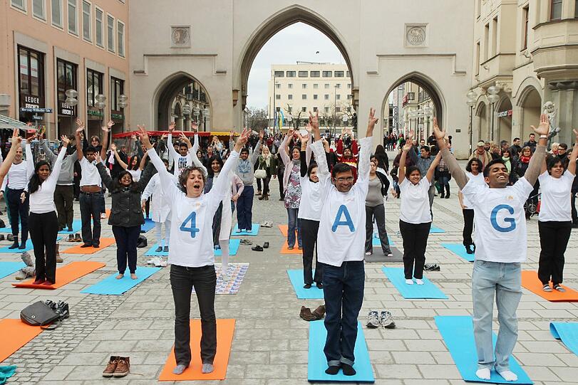 Hopsen und Dehnen in der Fußgängerzone: Am Stachus haben sich Yoga-Fans zu einem Flashmob unter freiem Himmel verabredet. Die Bilder.