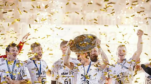 Kiels Spieler feiern mit der Meisterschale. Im Saisonfinale reichte dem THW ein Unentschieden in Mannheim.