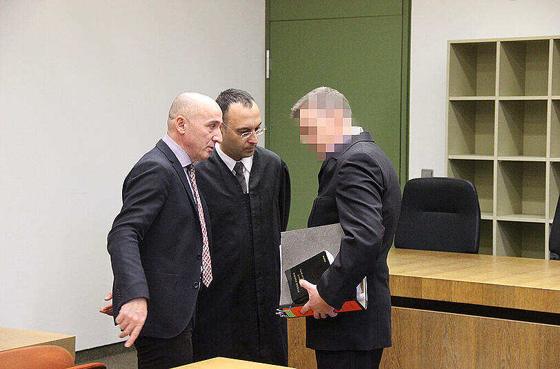 Der Angeklagte im Gespräch mit Anwalt und Dolmetscher (l.).
