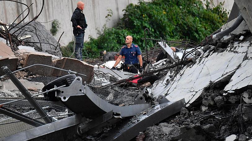 Rettungsarbeiten unter den Trümmern der eingestürzten Morandi Autobahnbrücke.