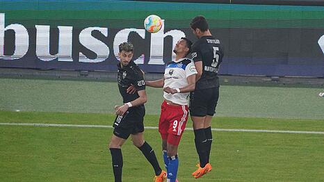 Hamburgs Robert Glatzel im Luftzweikampf gegen die Stuttgarter Atakan Karazor (l) und Konstantinos Mavropanos.