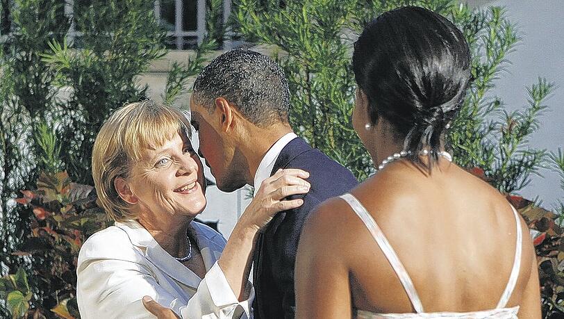 Er küsst, sie guckt: US-Präsident Barack Obama begrüßt Kanzlerin Angela Merkel. Michelle Obama (von hinten) schaut zu. Foto: Reuters Er küsst, sie guckt: US-Präsident Barack Obama begrüßt Kanzlerin Angela Merkel. Michelle Obama (von hinten) schaut zu. Foto: Reuters