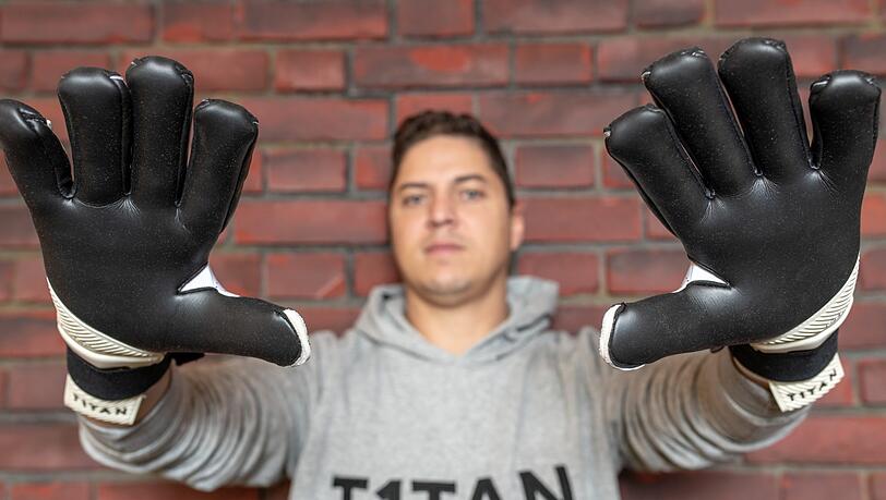 Matthias Leibitz, Geschäftsführer der T1TAN GmbH, steht in den Geschäftsräumen und trägt Torwarthandschuhe, die sein Unternehmen herstellt. Matthias Leibitz, Geschäftsführer der T1TAN GmbH, steht in den Geschäftsräumen und trägt Torwarthandschuhe, die sein Unternehmen herstellt.