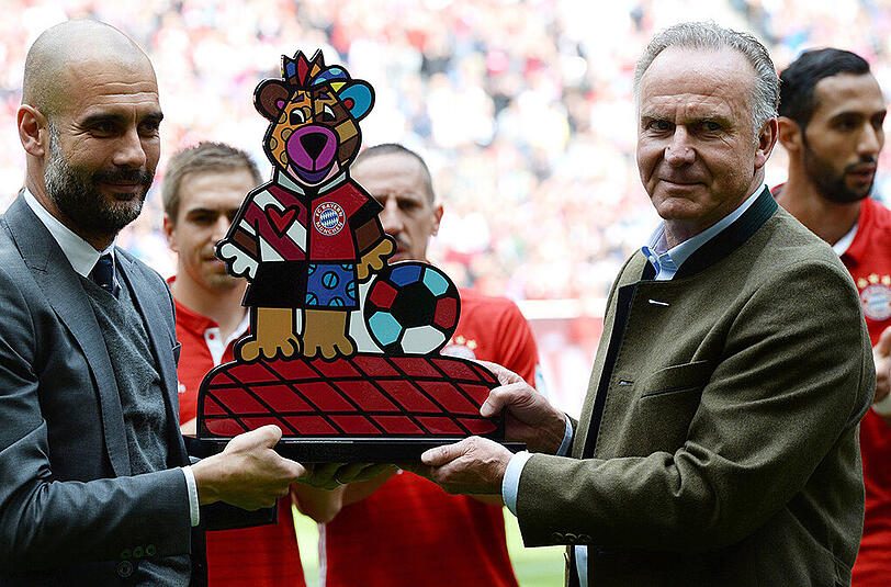 Bayern-Vorstandsboss Karl-Heinz Rummenigge überreicht dem scheidenden Trainer Pep Guardiola (links) das Bayern-Maskottchen Berni.