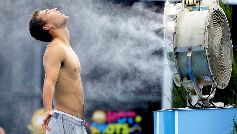 Der Pole Jerzy Janowicz kühlt sich während eines Matchs vor einem Ventilator ab. Der Pole Jerzy Janowicz kühlt sich während eines Matchs vor einem Ventilator ab.