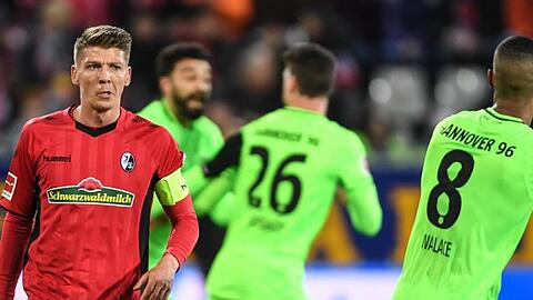 Hinter Mike Frantz (l) vom SC Freiburg feiern die Spieler von Hannover 96 das 1:1.