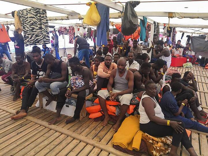 Migranten warten an Bord des spanischen Rettungsschiffs "Open Arms" auf das Anlegen.