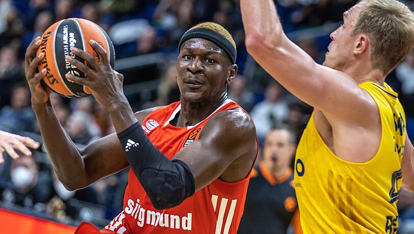 Isaac Bonga von Bayern München spielt den Ball neben Albas Luke Sikma (r).