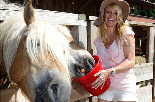 Sex-Symbol Pamela Anderson füttert Pferde auf Gut Aiderbichl.