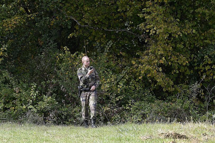 Ein Soldat steht neben der Landstraße, auf der sich das Unglück ereignete.