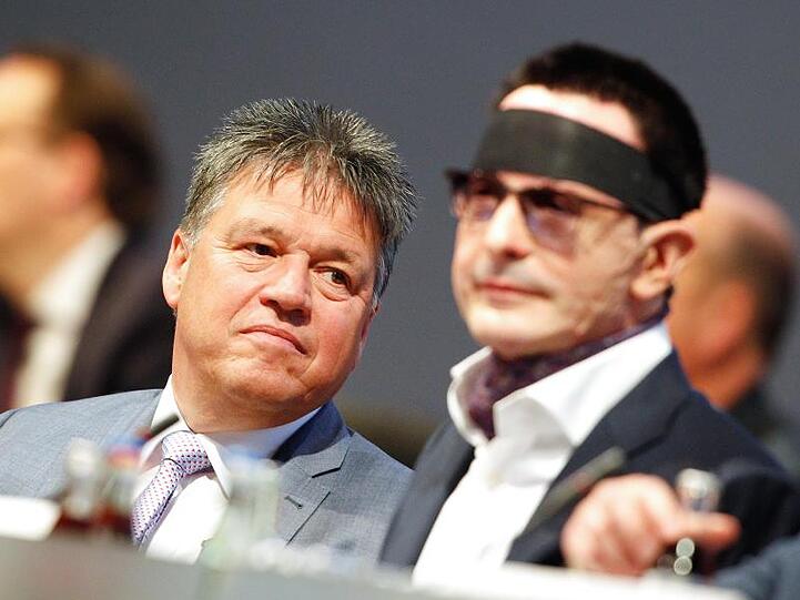 Uwe Tigges (l), Vorstandsvorsitzender der Innogy AG, und Bernhard Günther, der durch einen Säureanschlag vor einem Jahr verletzte Finanzvorstand der Innogy AG, auf der Hauptversammlung.