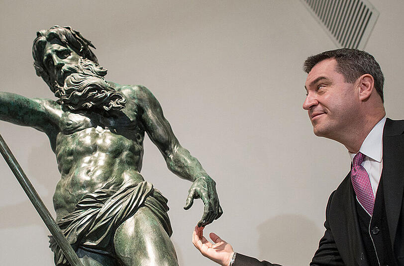 Bayerns Finanzminister Markus Söder in der Residenz neben einer Neptun-Statue.