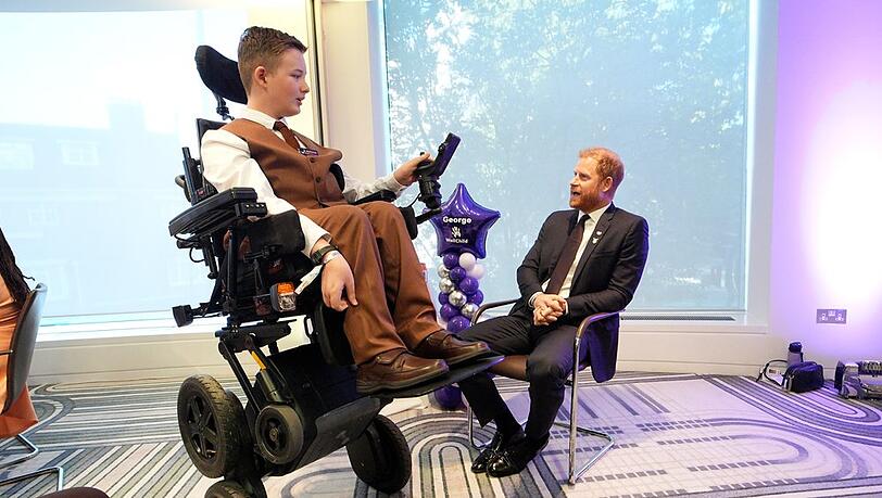 George, einer der jungen Gewinner, zeigt Harry seinen neuen Rollstuhl. George, einer der jungen Gewinner, zeigt Harry seinen neuen Rollstuhl.