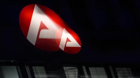 Das Logo der Bundesagentur für Arbeit leuchtet über einem Büro.