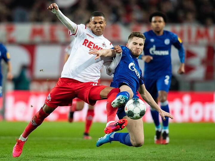 Der Kölner Ismail Jakobs (l) setzt sich im Zweikampf mit dem Schalker Jonjoe Kenny durch.