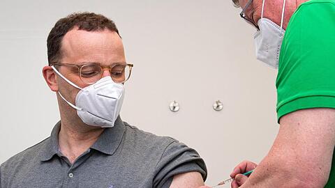 Jens Spahn (l,CDU), Bundesminister für Gesundheit, wird in einer Hausarztpraxis mit dem Impfstoff AstraZeneca geimpft.