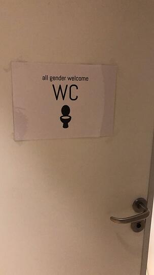 An der Tür der Frauentoilette hing ein Schild, dass hier alle Geschlechter willkommen sind