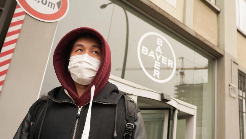 Ein Mann mit Mundschutz geht an einem Logo des Chemiekonzerns Bayer vorbei. Ein Mann mit Mundschutz geht an einem Logo des Chemiekonzerns Bayer vorbei.