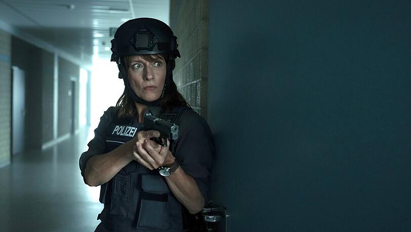 "Polizeiruf 110: Sie sind unter uns": Brasch (Claudia Michelsen) betritt mit vorgehaltener Waffe ein Klassenzimmer.