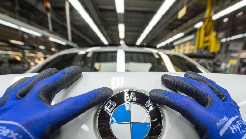 Ein Mitarbeiter montiert ein BMW-Emblem auf den Kofferraumdeckel eines Fahrzeugs der 7er Reihe. Foto: Armin Weigel/Archiv Ein Mitarbeiter montiert ein BMW-Emblem auf den Kofferraumdeckel eines Fahrzeugs der 7er Reihe. Foto: Armin Weigel/Archiv