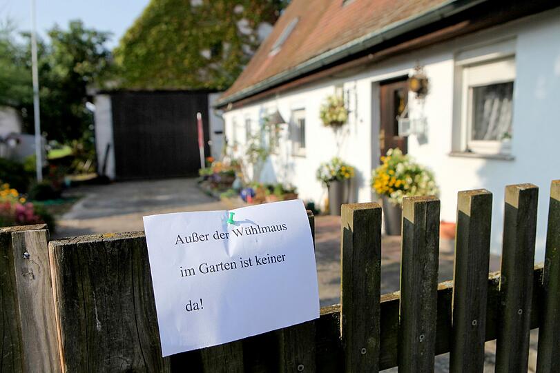 Ein Zettel mit der Aufschrift "Außer der Wühlmaus im Garten ist keiner da!" hängt am 07.09.2014 in Nürnberg (Bayern) am Gartenzaun von einem evakuierten Haus.