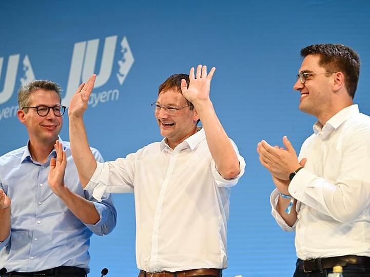 Markus Blume (l.) und Christian Doleschal (r.) applaudieren dem scheidenden JU-Landeschef Hans Reichart.