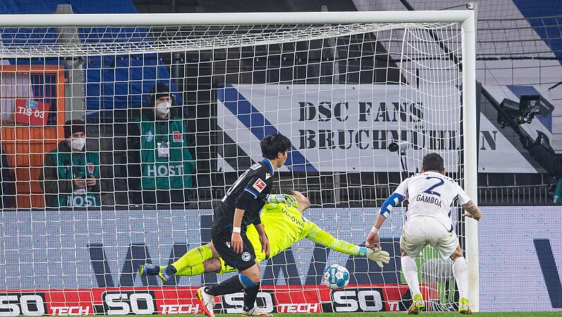 Bielefelds Masaya Okugawa (l) erzielt gegen Bochums Cristian Gamboa (r) und Torwart Manuel Riemann (M) das Führungstor.