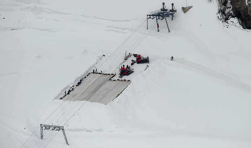 Arbeiter decken auf dem Zugspitzplatt bei Grainau den Gletscher mit einer Plane ab, um ein Abschmelzen zu verhindern. Deutschlands einziger Gletscher soll waehrend der warmen Sommermonate mit der 500 bis 600 Quadratmeter grossen Plane vor Sonne und Regen geschuetzt werden.