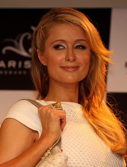 Typisch für Paris Hilton: Der Griff mit der rechten Hand zur Tasche.