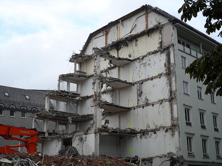 Der Abbruch des Hauses Maximiliansplatz 13 ist schon weit fortgeschritten. Nur ein Detail in luftiger Höhe macht klar, dass hier früher eine Bank untergebracht war.