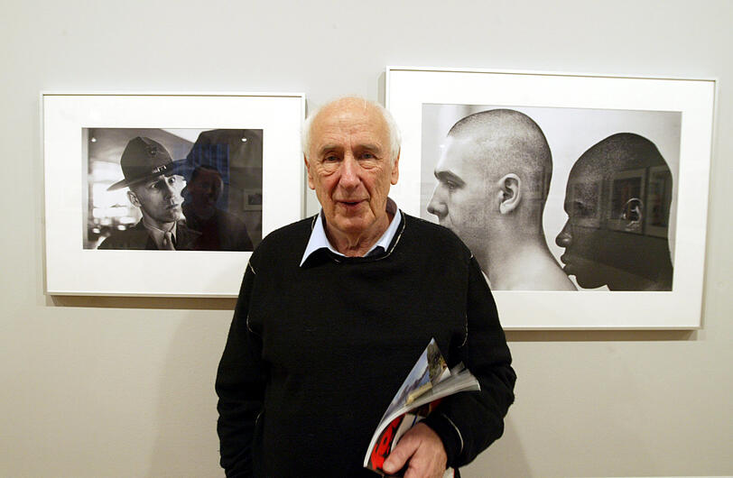 Thomas Hoepker 2005 im Fotomuseum des Münchner Stadtmuseums zwischen zwei seiner Fotos aus dem Jahr 1970. Sie gehören zu einer Serie, die im US Marines Boot Camp in Paris Island, USA, entstanden sind.